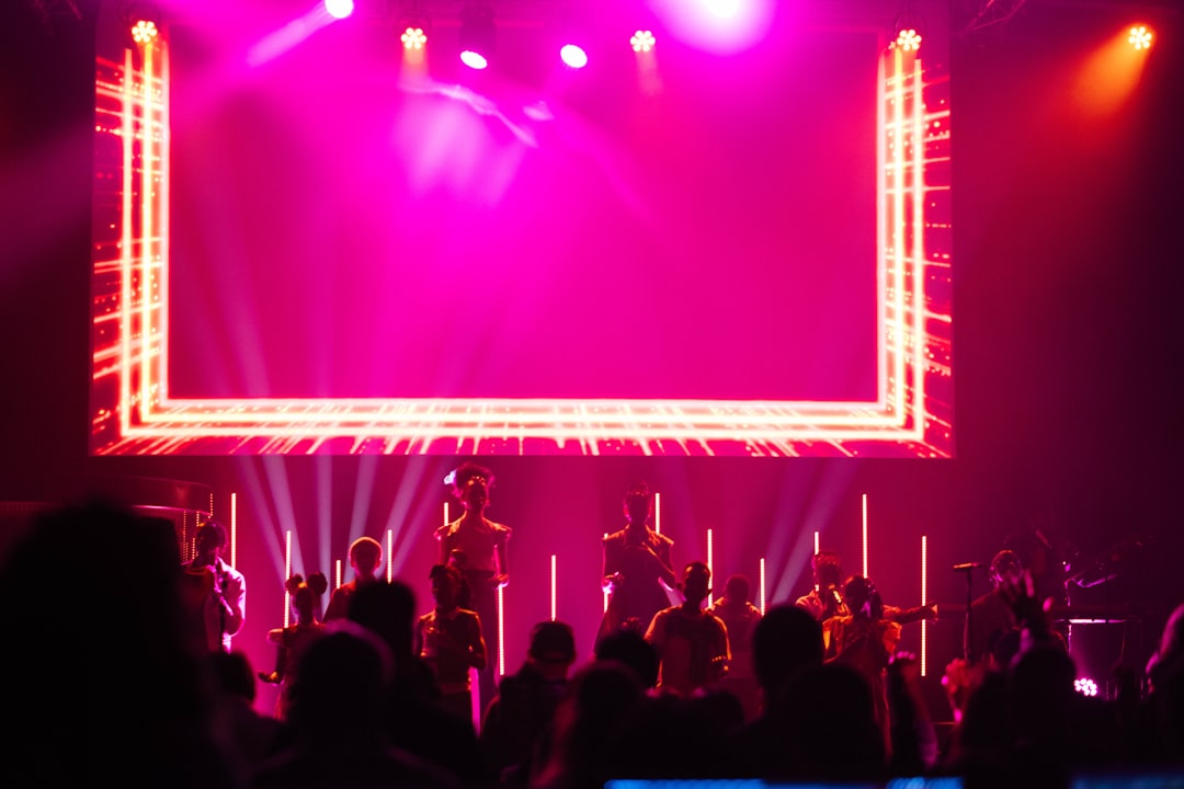 a-band-performs-on-stage-with-bright-pink-lighting-jx-umfkra5g